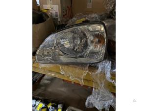 Gebruikte Koplamp links Kia Carens II (FJ) 1.6i 16V Prijs € 52,50 Margeregeling aangeboden door van de Bunte Teuge B.V.